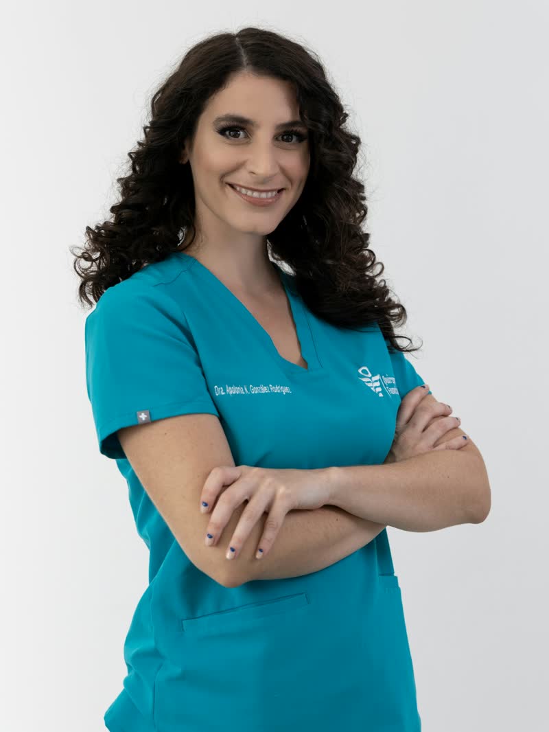 A clinician in teal scrubs with folded arms